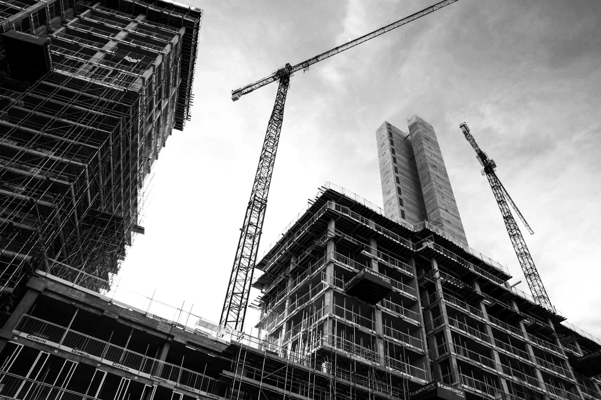 Concrete frame rising on site beneath tower cranes