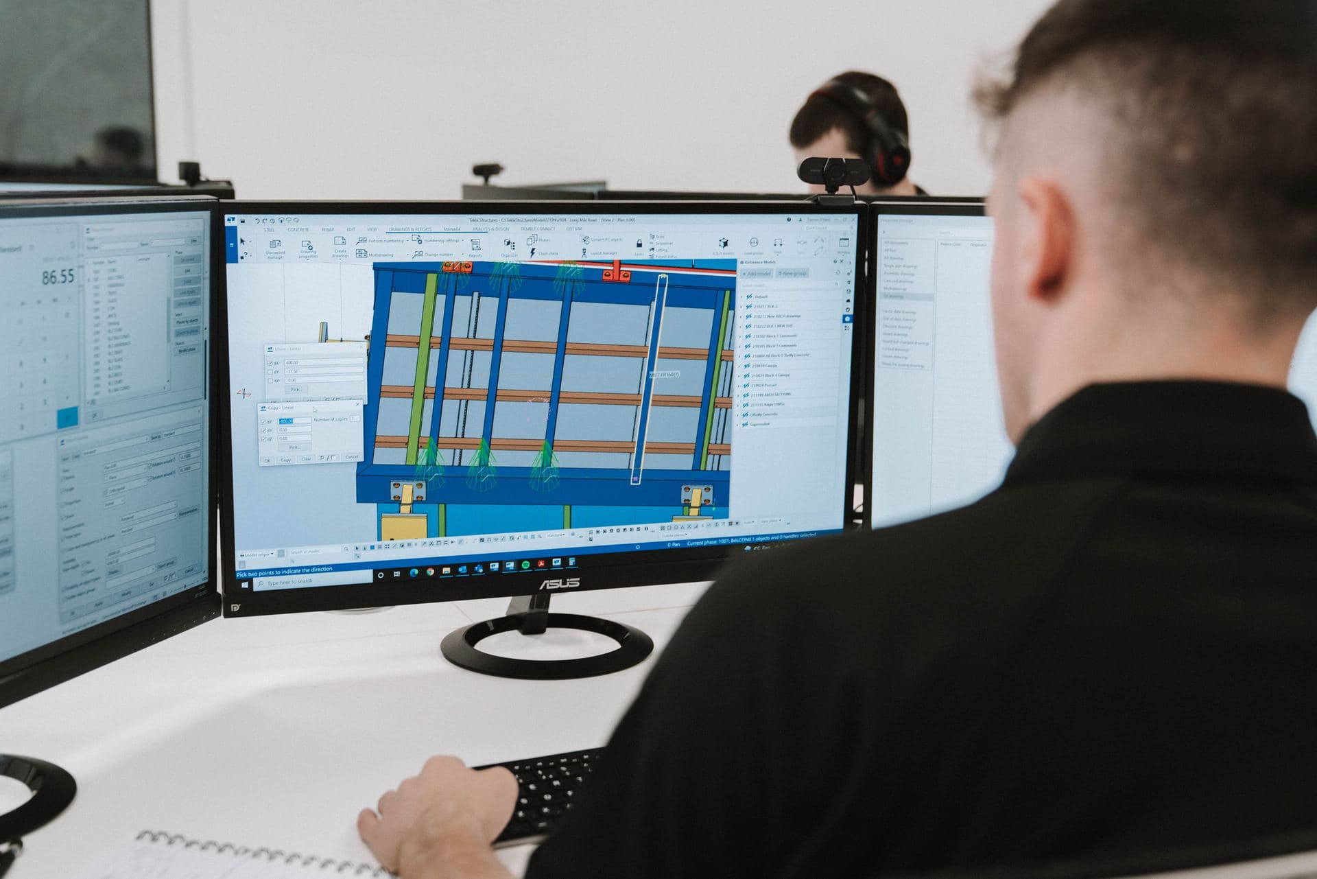 OD3 detailer reviewing a steel frame model in Tekla Structures across three monitors